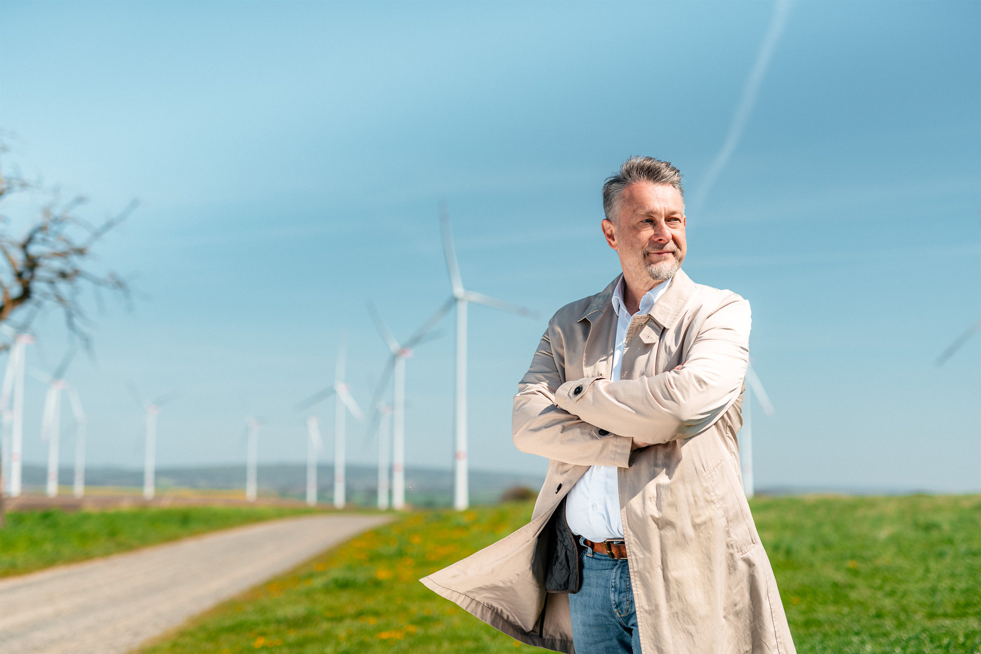 Portrait von Ivica Lukanic am Feld mit Windkraft